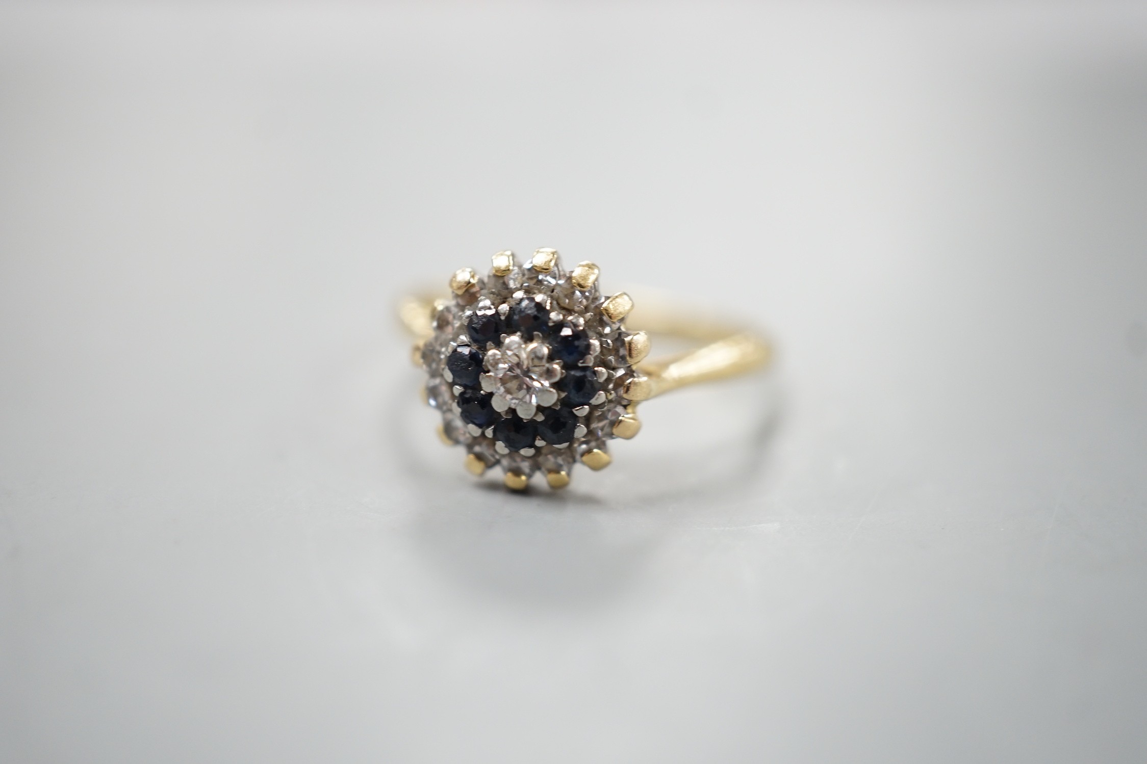 A 1960's 18ct gold, 18ct gold, sapphire and diamond set circular cluster ring, size O, gross weight 3.6 grams.